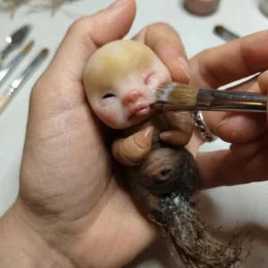 Primer plano de manos modelando una figura de arcilla personalizada por encargo en Libélula Nocturna.
