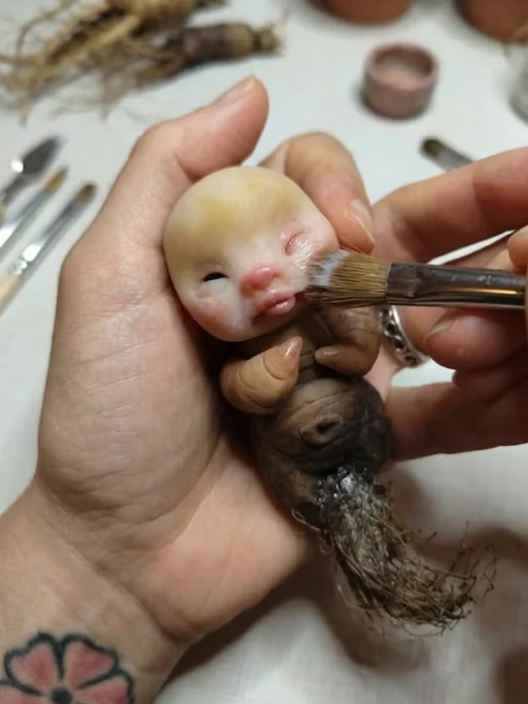 Primer plano de manos modelando una figura de arcilla personalizada por encargo en Libélula Nocturna.