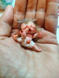 Por encargo 5 Escultura miniatura de hada recién nacida de arcilla polimérica durmiendo sobre algodón con musgo verde y seta amanita roja.
